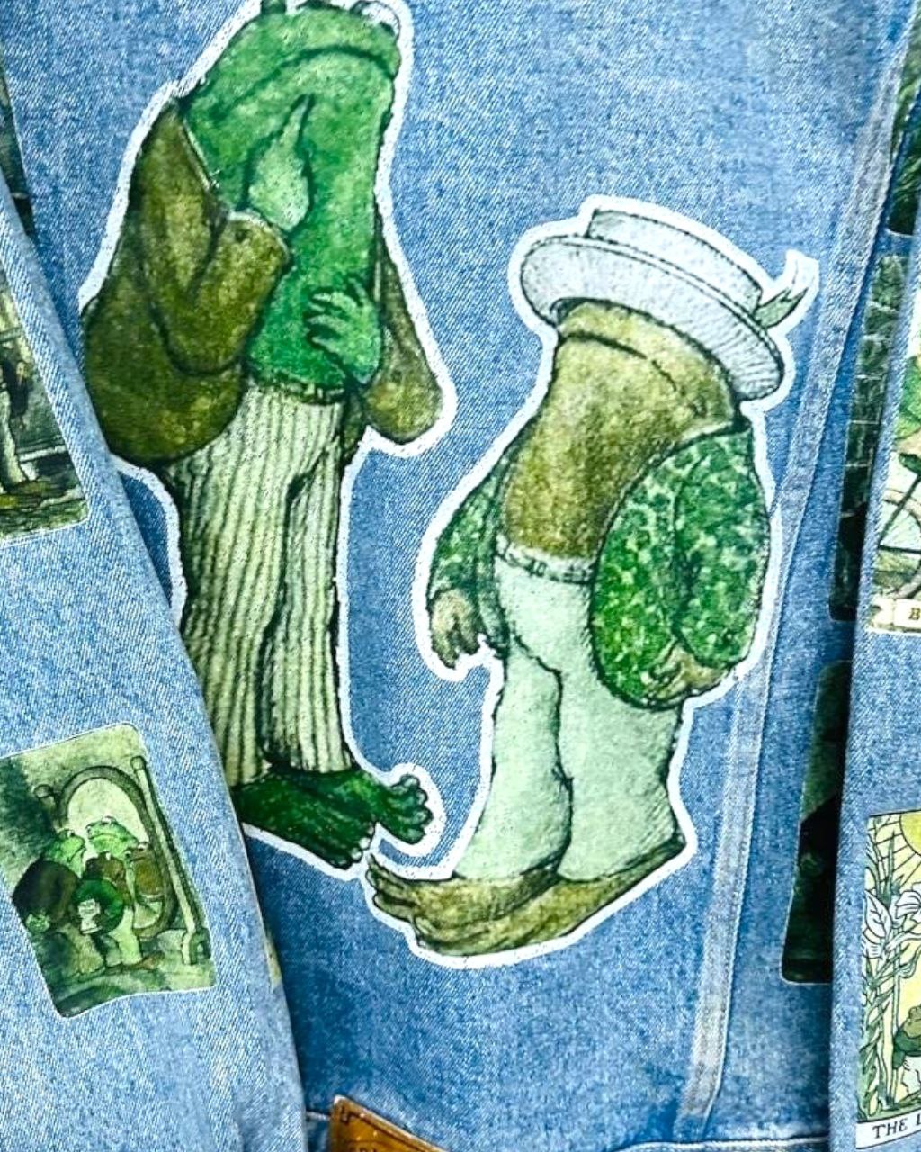 a denim jacket with pictures of frog and toad printed on it