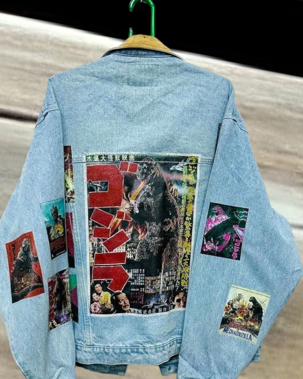 a denim jacket with pictures of japanese godzilla printed on it