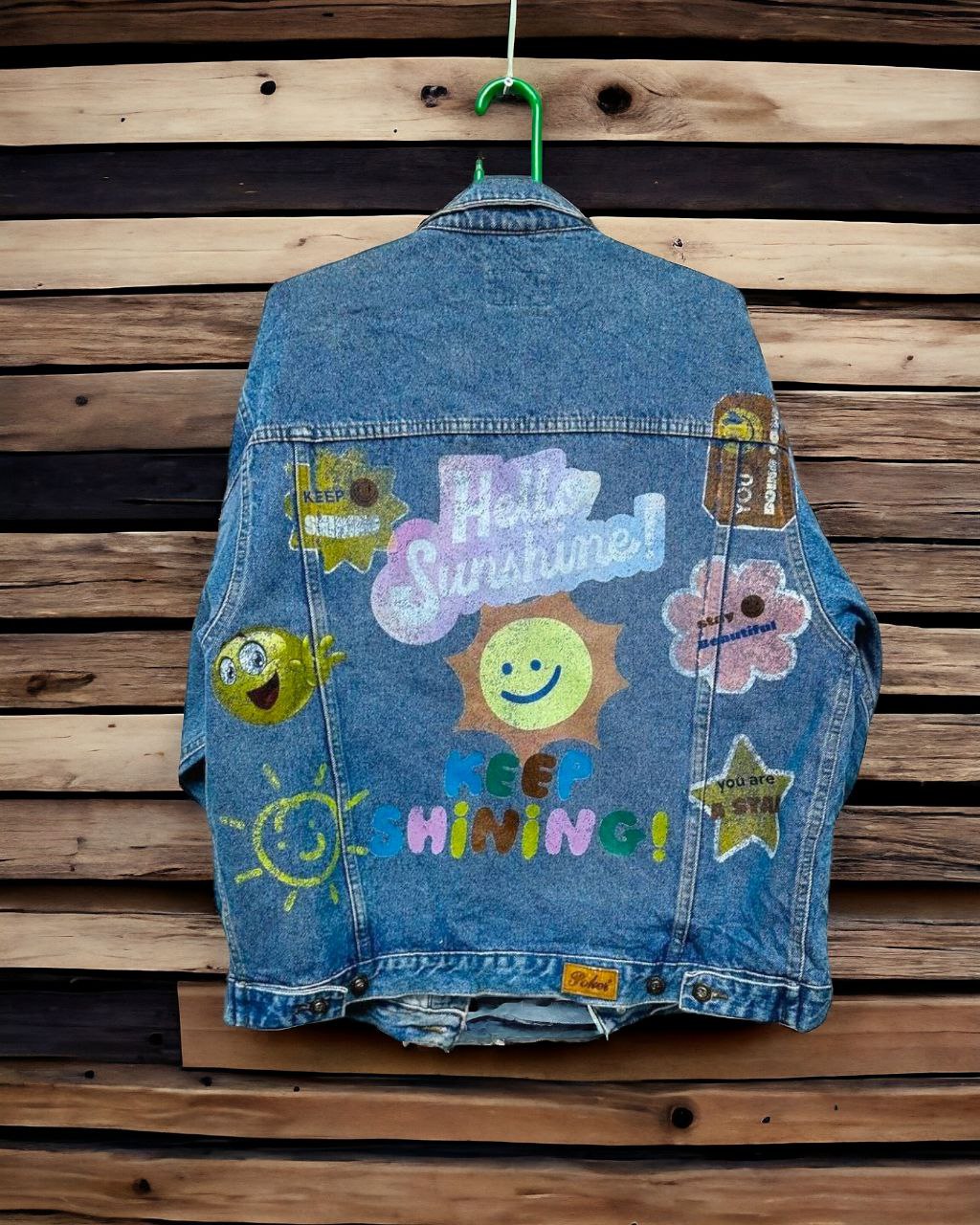 a denim jacket with pictures of  letters and expressions printed on it