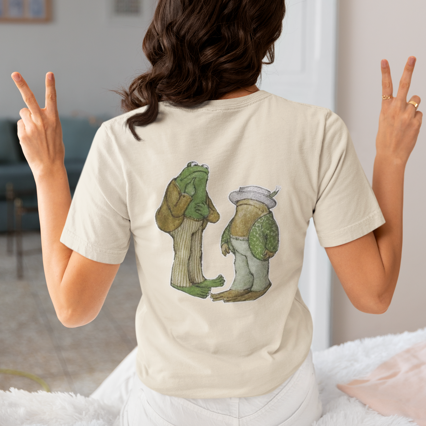 a woman wearing a beige frog and toad  t - shirt