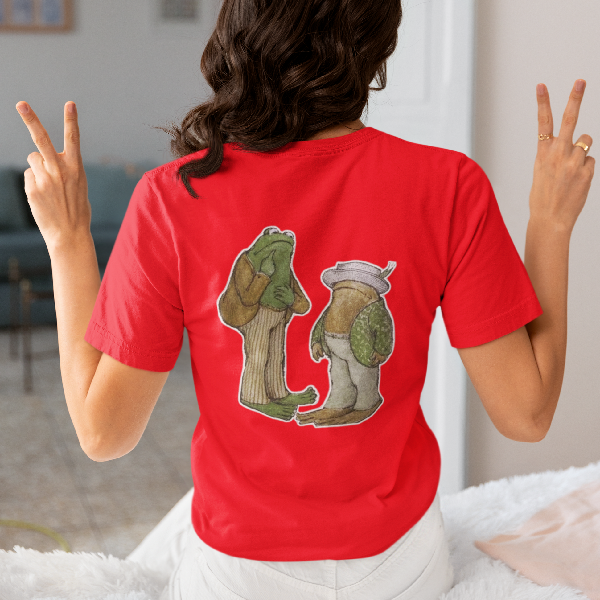 a woman wearing a red frog and toad  t - shirt