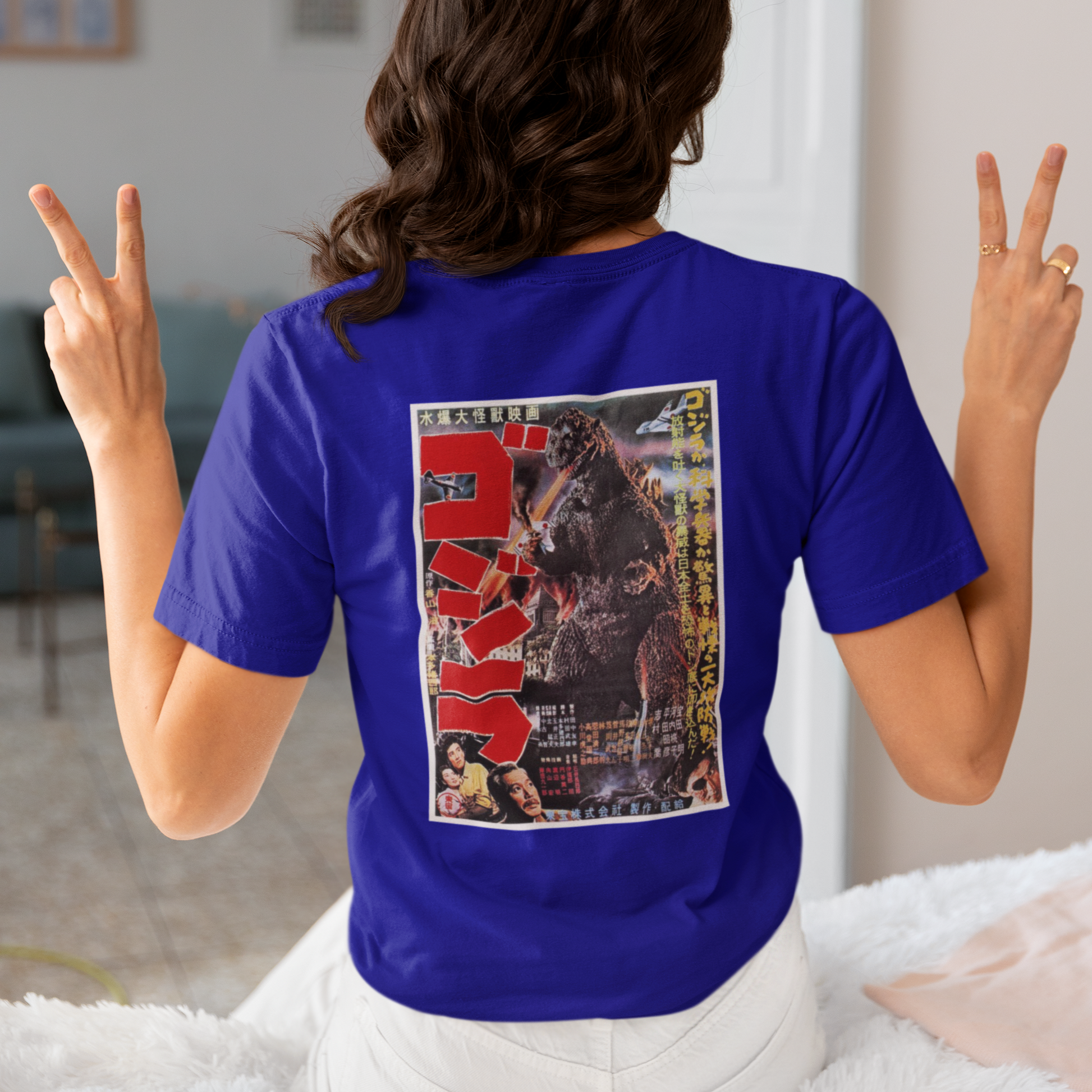 a woman wearing a blue japanese godzilla  t - shirt