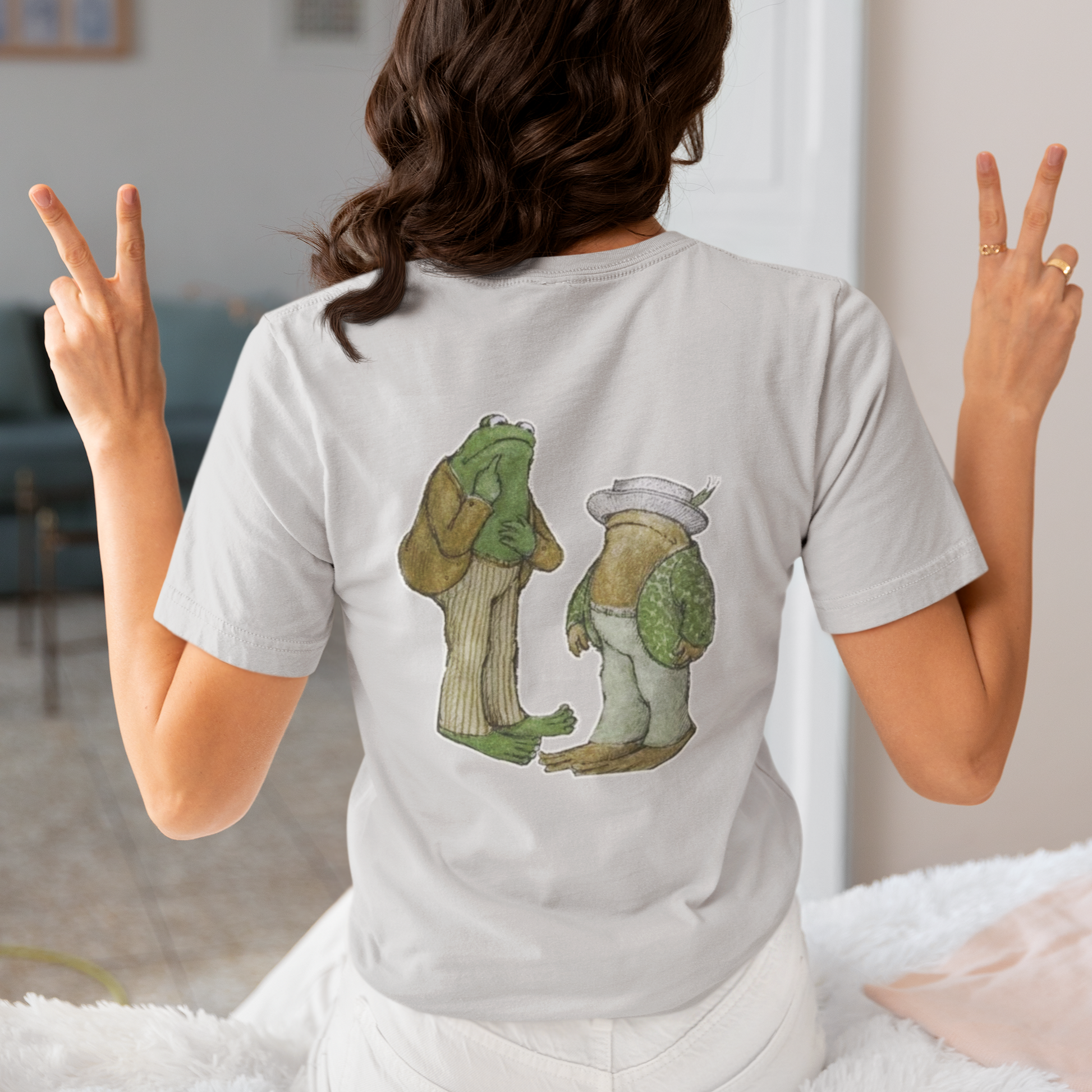 a woman wearing a grey frog and toad  t - shirt