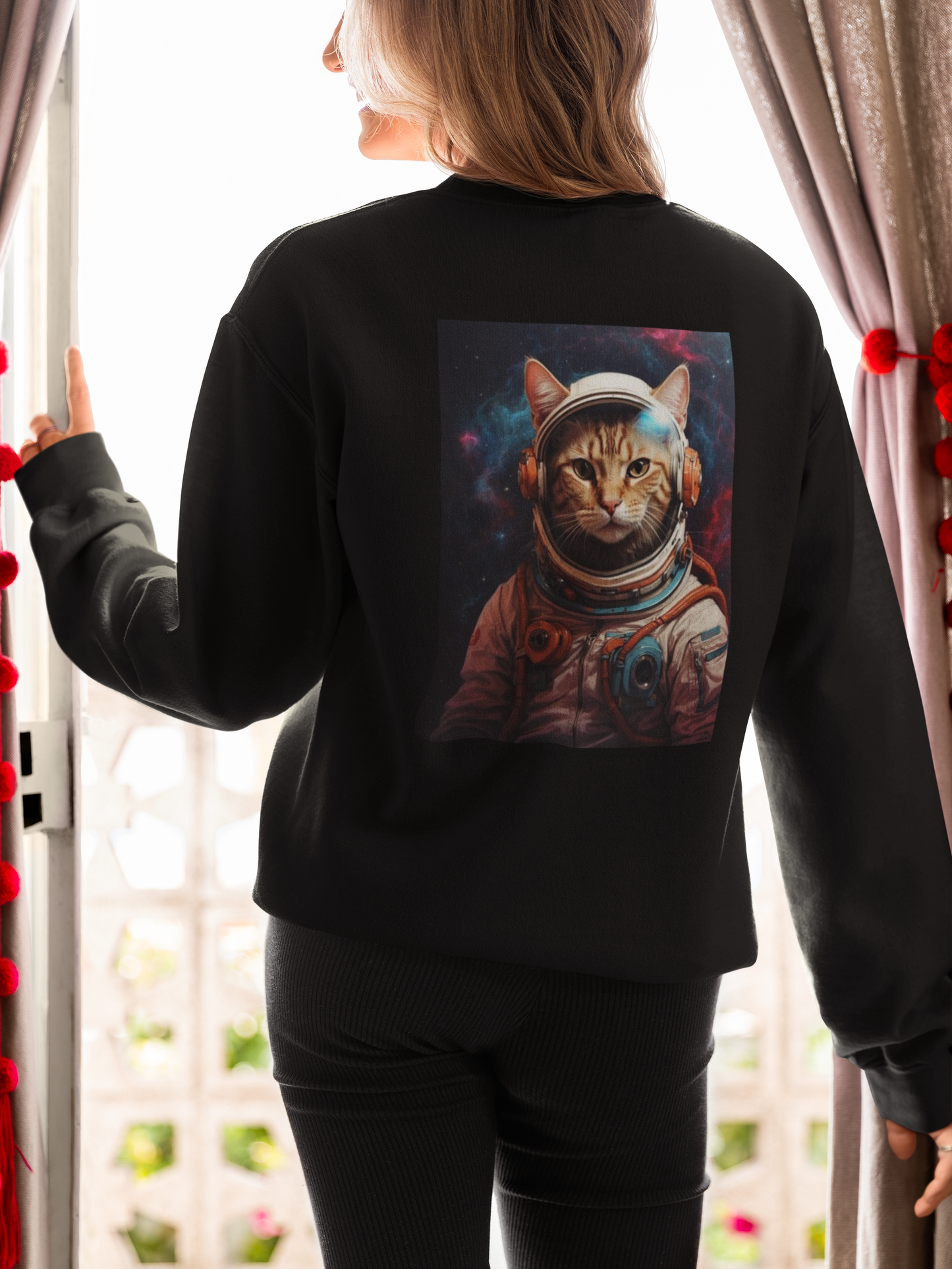 a woman wearing a black space cat sweatshirt