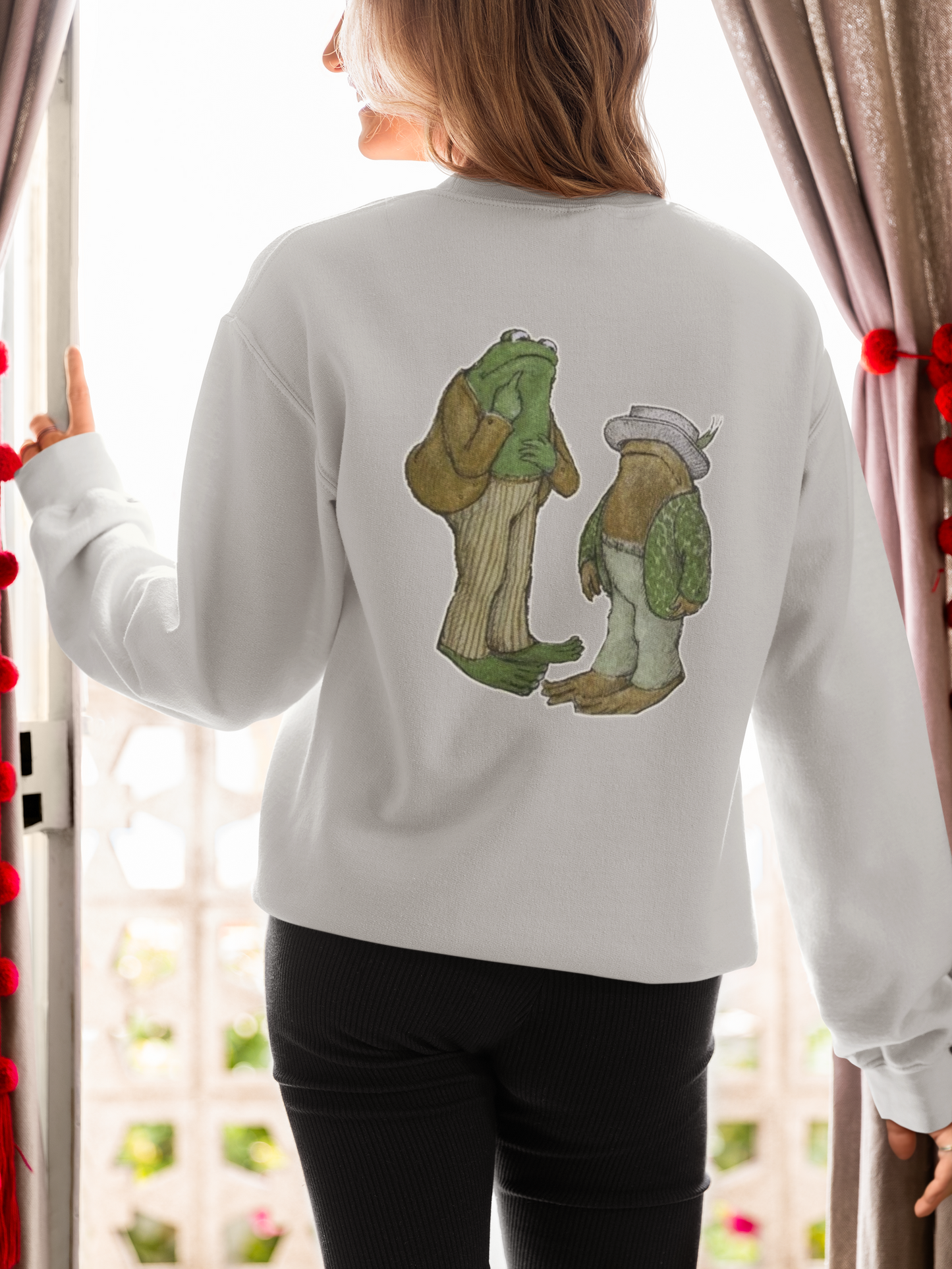 a picture of a woman wearing a grey frog and toads sweatshirt