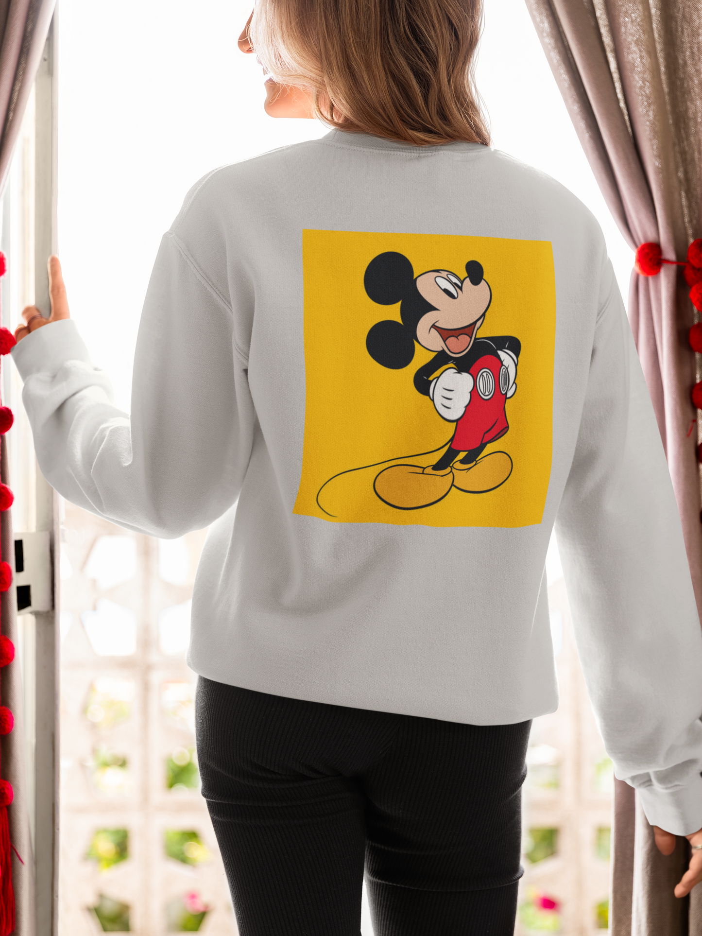 a woman wearing a grey mickey mouse  sweatshirt