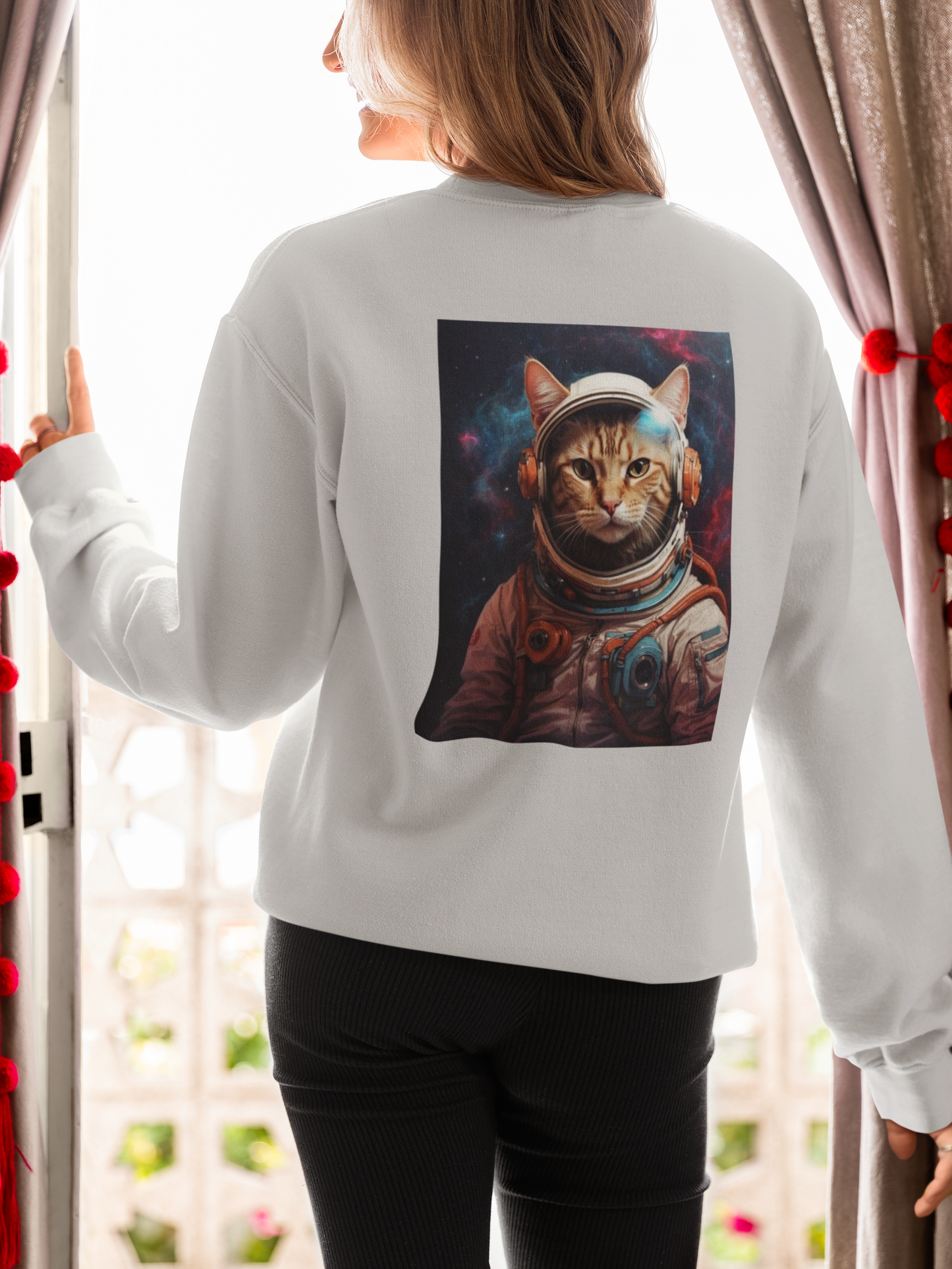 a woman wearing a grey space cat sweatshirt