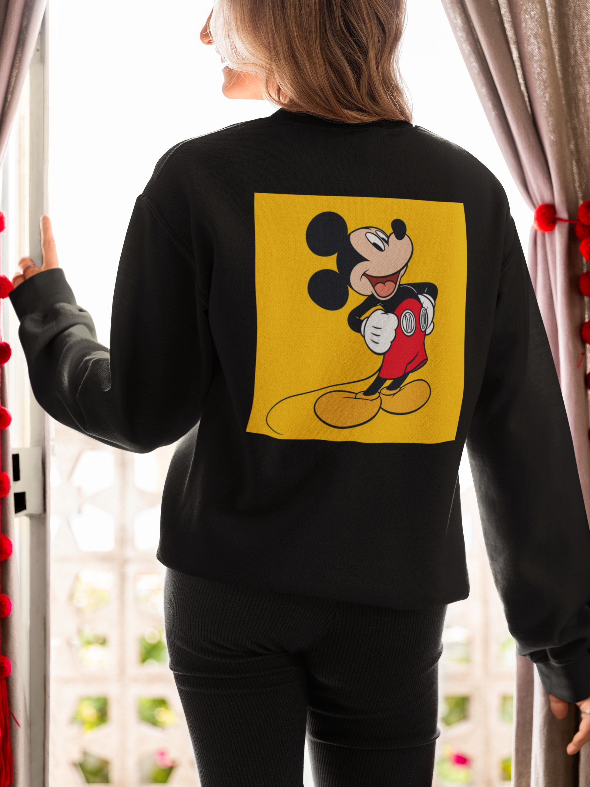 a woman wearing a black mickey mouse  sweatshirt