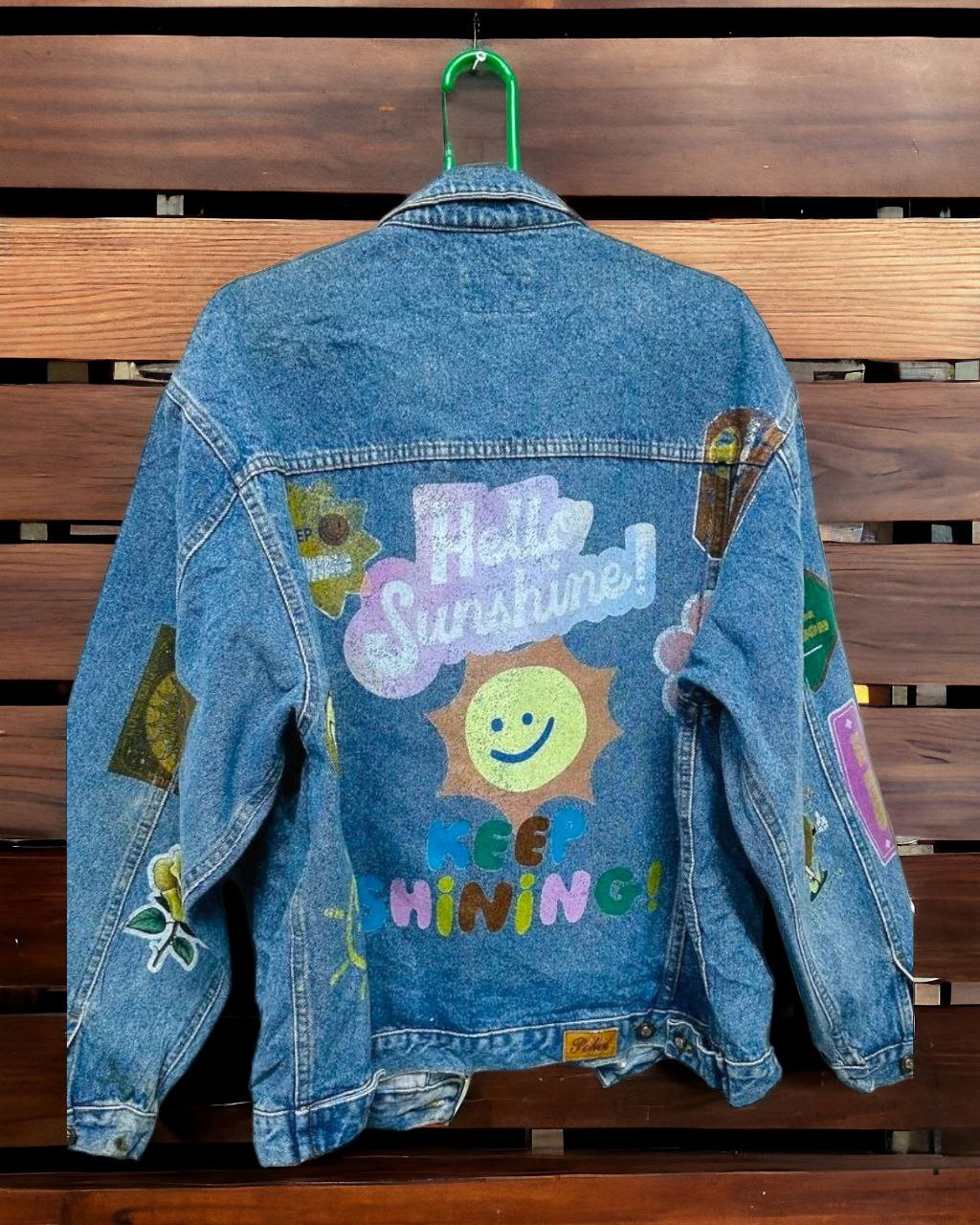 a denim jacket with pictures of  letters and expressions printed on it