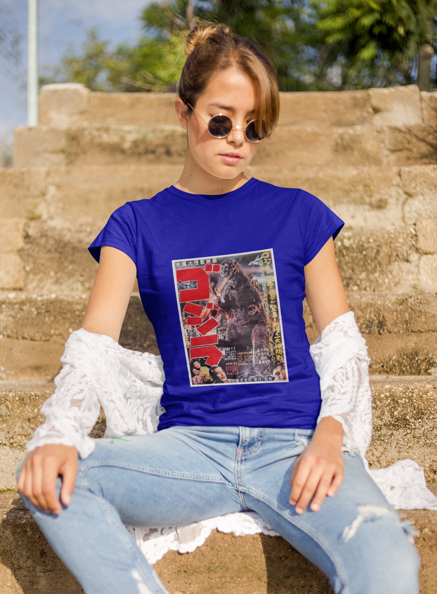 a woman wearing a blue japanese godzilla  t - shirt