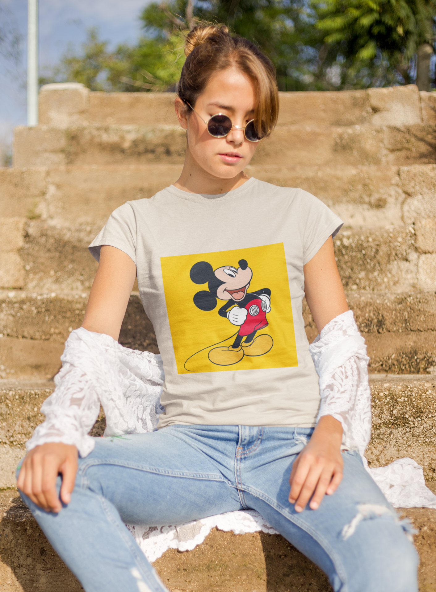 a woman wearing a beige Mickey mouse T-shirt