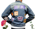a man wearing a jean jacket with stickers on it