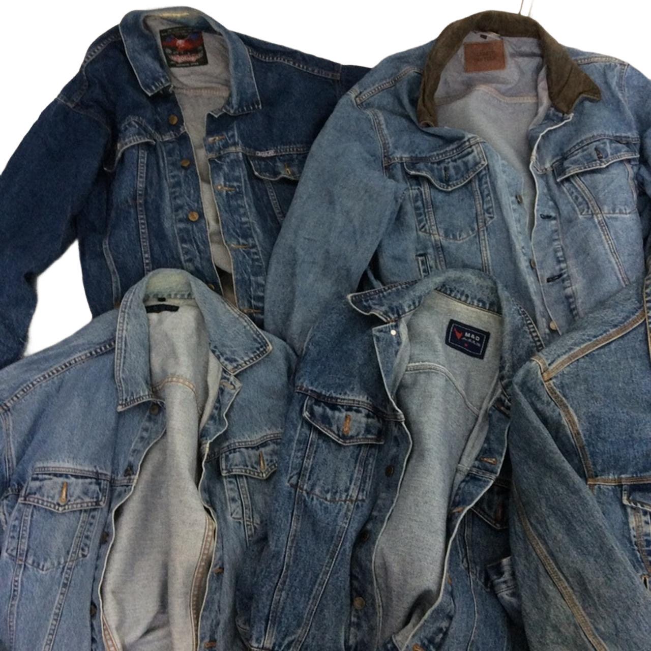 a pile of blue jean jackets sitting on top of each other