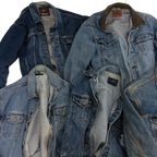 a pile of blue jean jackets sitting on top of each other
