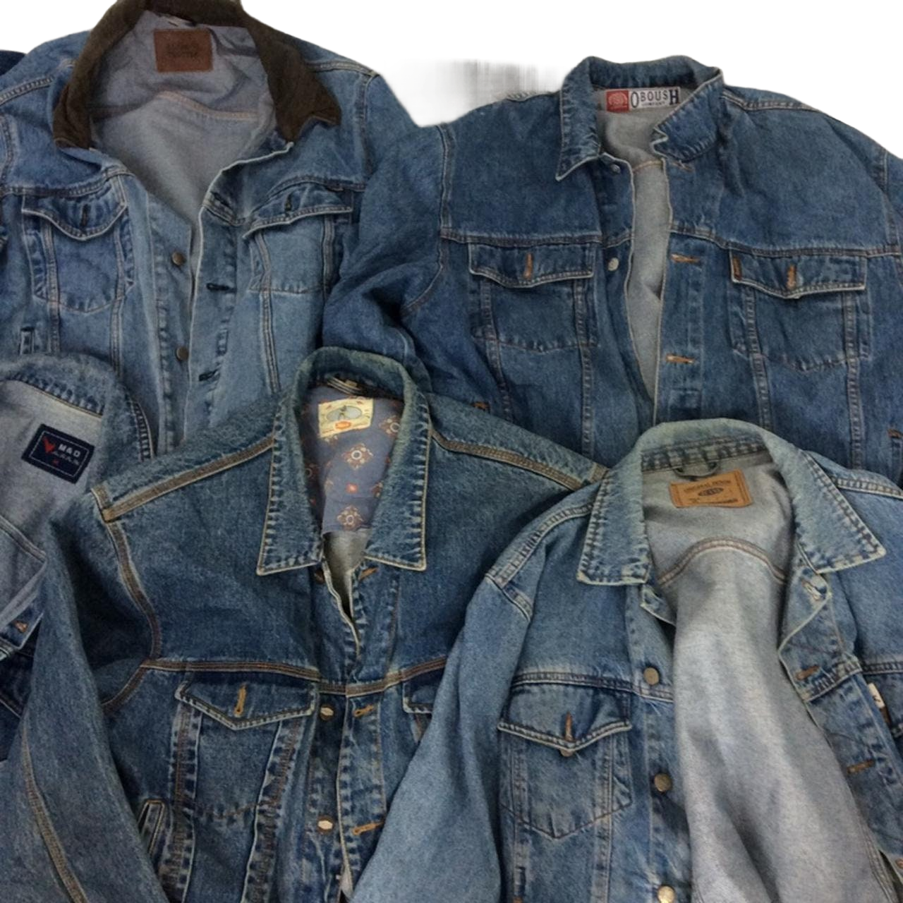 a pile of blue jean jackets laying on top of each other